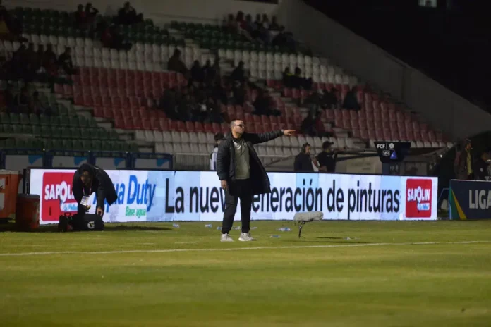 Estadio de fútbol con torres de iluminación apagadas durante el atardecer en Colombia.